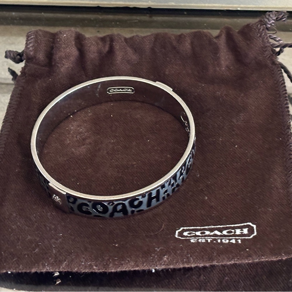 Coach Signature Hinged Bangle in a grey/silver color scheme